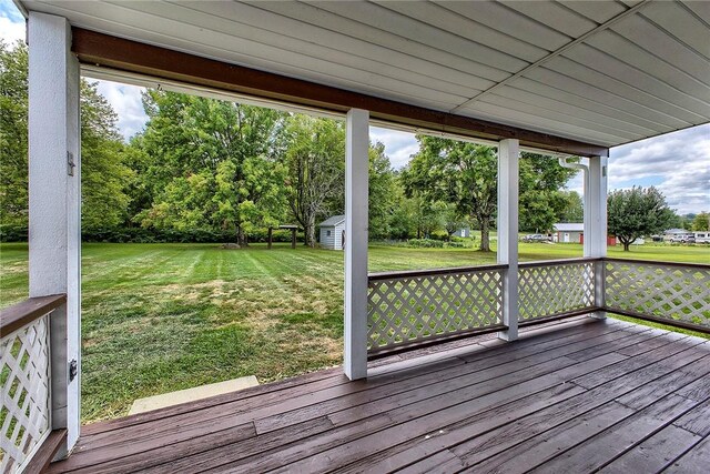 deck with a yard and a shed