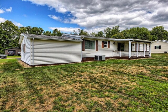 back of house with a lawn and central AC