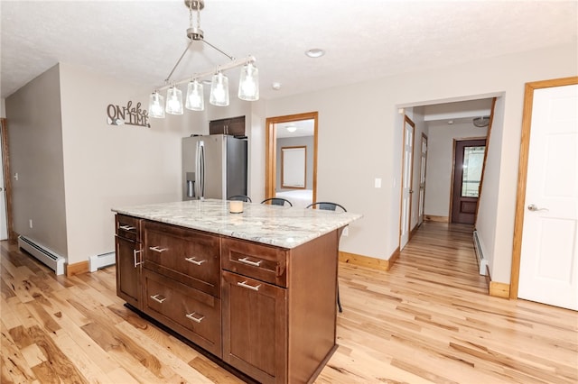 kitchen with stainless steel refrigerator with ice dispenser, a center island, light hardwood / wood-style floors, decorative light fixtures, and a baseboard heating unit