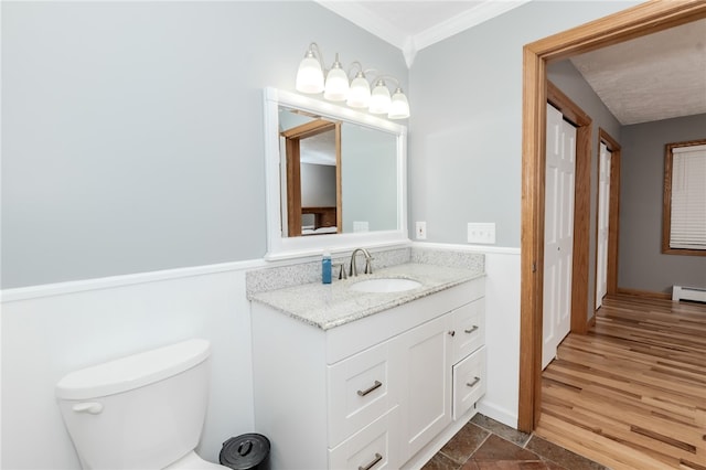 bathroom with toilet, crown molding, hardwood / wood-style flooring, and vanity