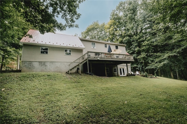 rear view of house featuring a deck and a lawn