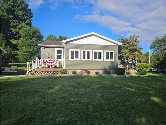 view of front facade featuring a front yard and a wooden deck