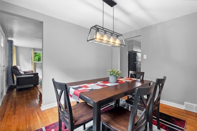 dining area featuring hardwood / wood-style floors and a chandelier