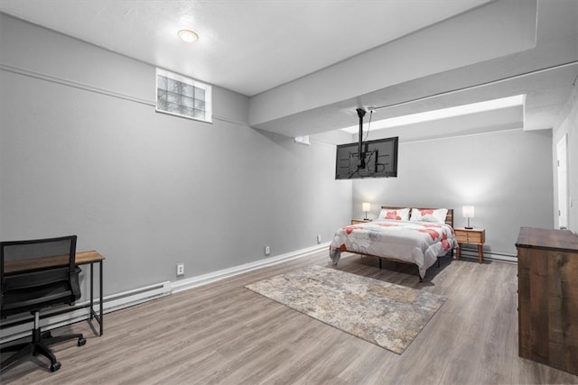 bedroom featuring a baseboard radiator and hardwood / wood-style flooring