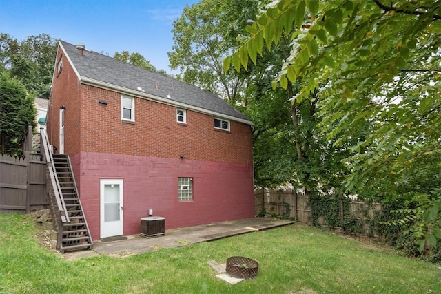 back of house with central AC and a yard