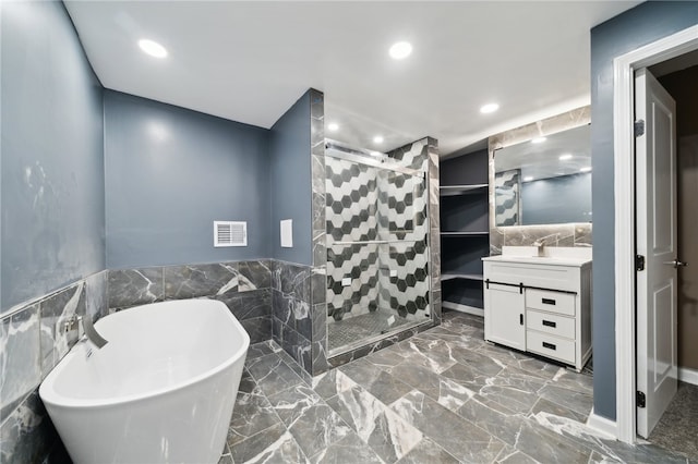 bathroom featuring tile patterned flooring, tile walls, independent shower and bath, and vanity