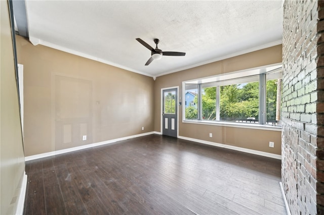 spare room with ceiling fan, a textured ceiling, a brick fireplace, and wood-type flooring