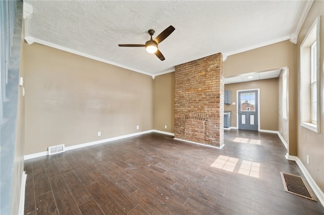 interior space featuring ceiling fan, brick wall, ornamental molding, hardwood / wood-style flooring, and a textured ceiling