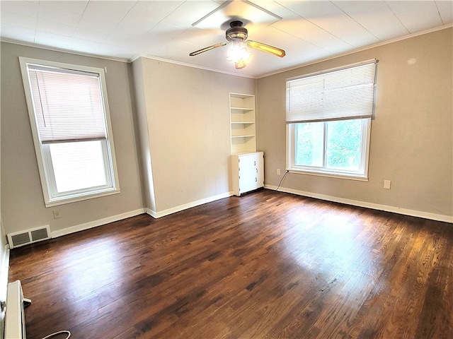 empty room featuring ceiling fan, hardwood / wood-style floors, crown molding, and built in shelves