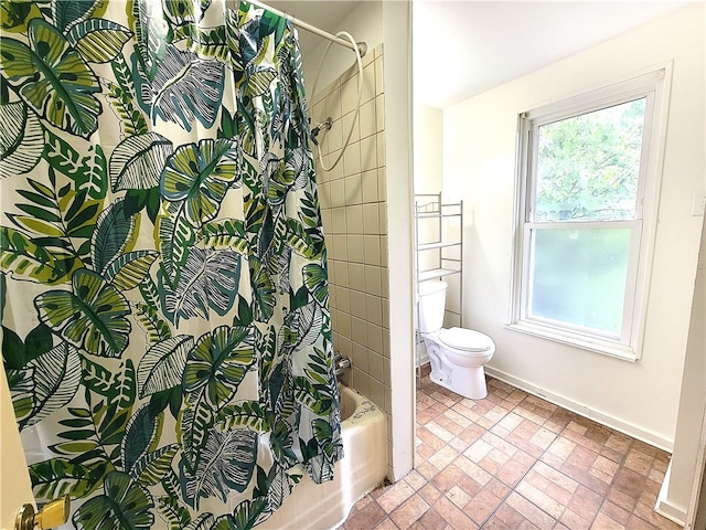 bathroom featuring toilet, shower / bath combo with shower curtain, and tile patterned flooring