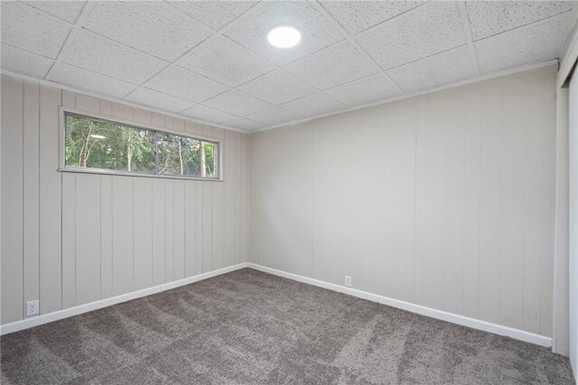 spare room featuring a drop ceiling and carpet