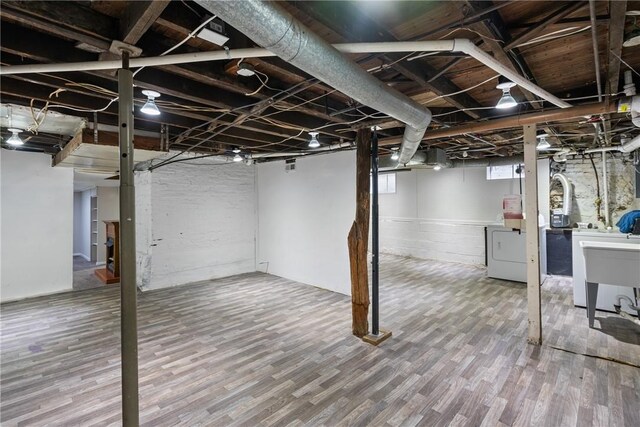 basement featuring hardwood / wood-style floors and washer / dryer