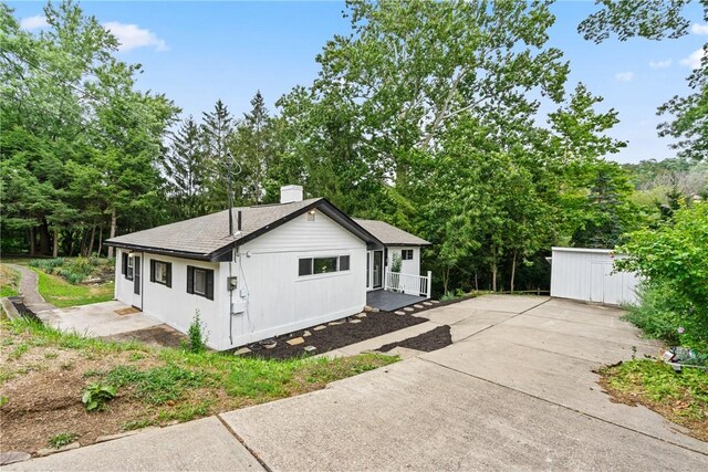 view of side of home featuring a storage shed