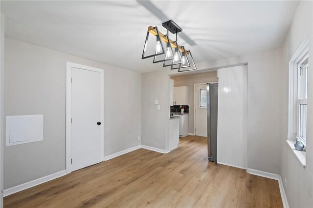 unfurnished dining area featuring light wood-type flooring