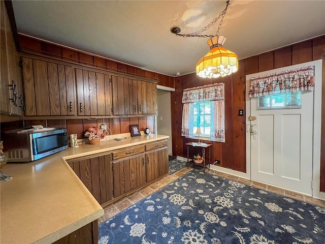 kitchen featuring hanging light fixtures and wood walls