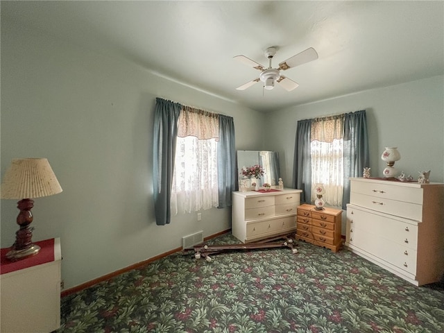 carpeted bedroom featuring multiple windows and ceiling fan