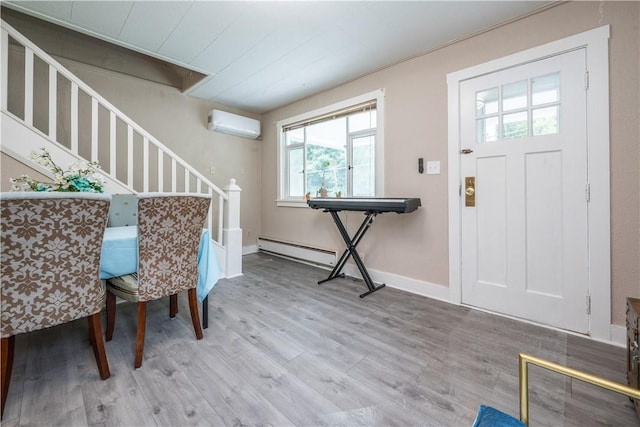 entryway with a wall mounted air conditioner, stairway, baseboards, and wood finished floors