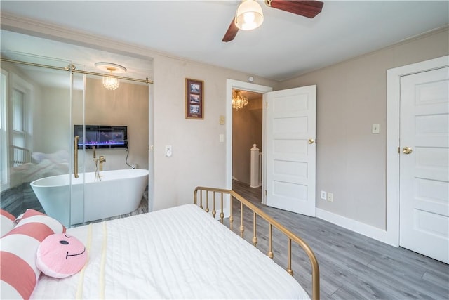 bedroom with ceiling fan with notable chandelier, baseboards, and wood finished floors