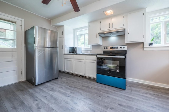 kitchen with under cabinet range hood, range with electric stovetop, white cabinets, light wood-type flooring, and freestanding refrigerator