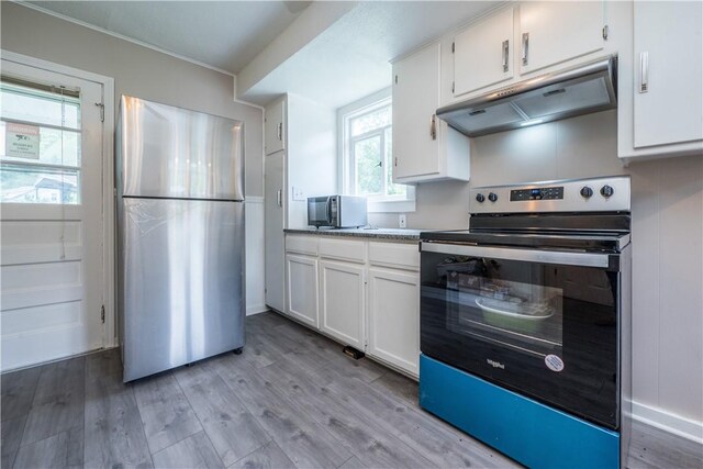 kitchen with appliances with stainless steel finishes, light hardwood / wood-style floors, and white cabinets