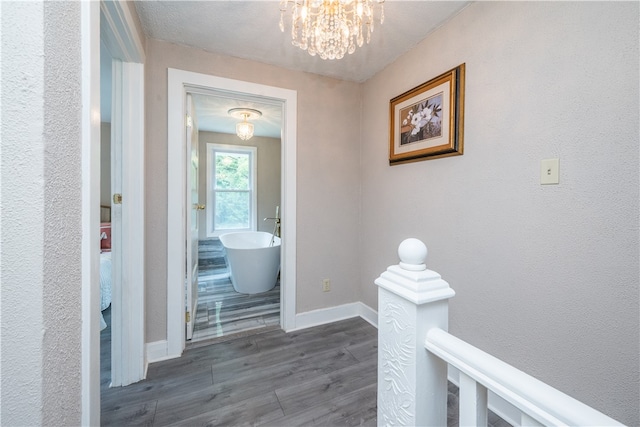 hallway featuring dark hardwood / wood-style floors and a notable chandelier