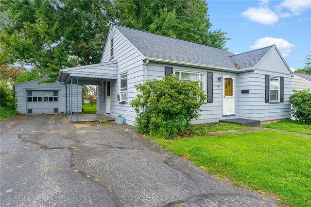 view of front of home featuring a garage, a front lawn, and an outbuilding