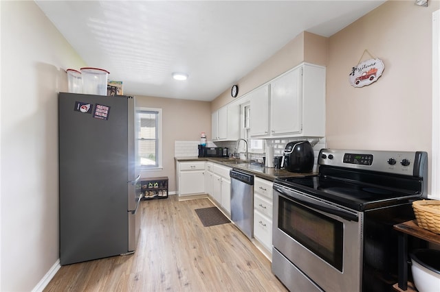 kitchen with light hardwood / wood-style flooring, white cabinets, appliances with stainless steel finishes, and sink