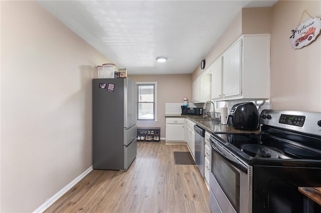 kitchen featuring white cabinets, appliances with stainless steel finishes, and light hardwood / wood-style floors