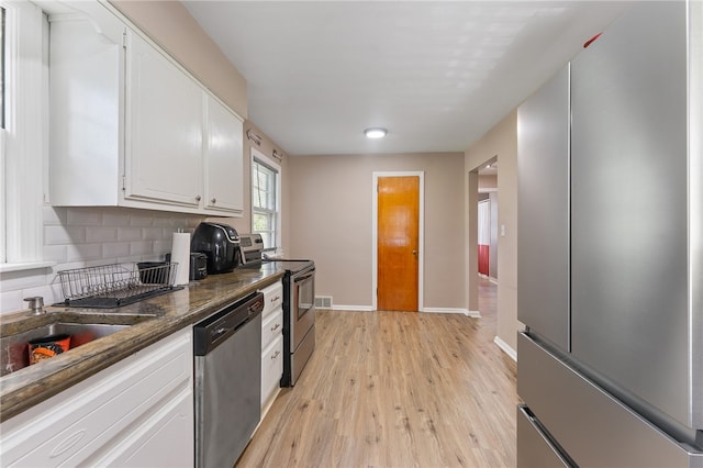 kitchen with light wood-type flooring, stainless steel appliances, and white cabinetry