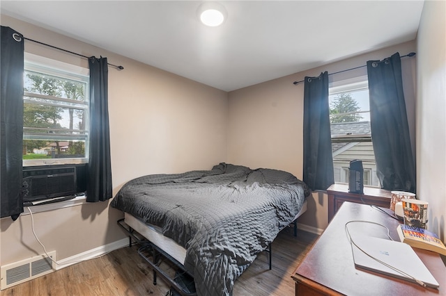 bedroom featuring wood-type flooring and cooling unit