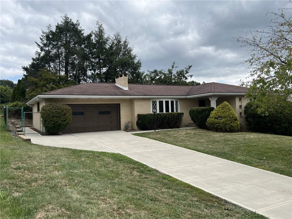 single story home featuring a front yard and a garage