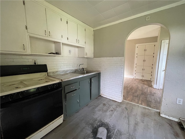 kitchen with sink, dark hardwood / wood-style flooring, decorative backsplash, gray cabinetry, and white range with electric cooktop