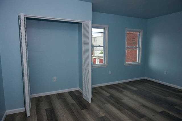 unfurnished bedroom featuring dark hardwood / wood-style floors