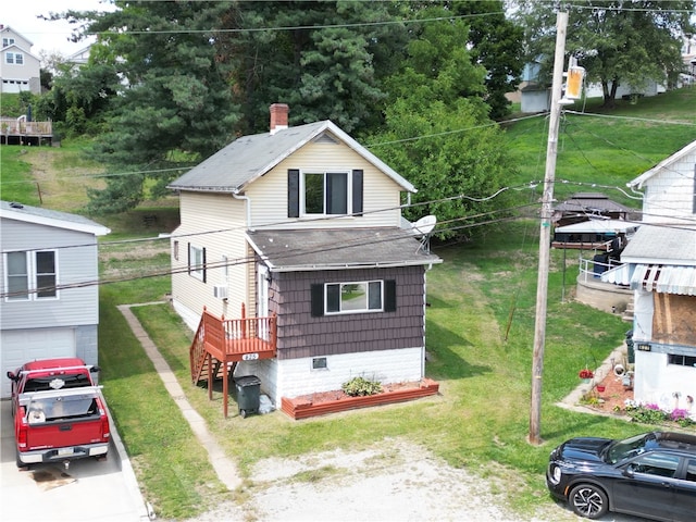 view of front of home featuring a wooden deck, a front yard, and a garage