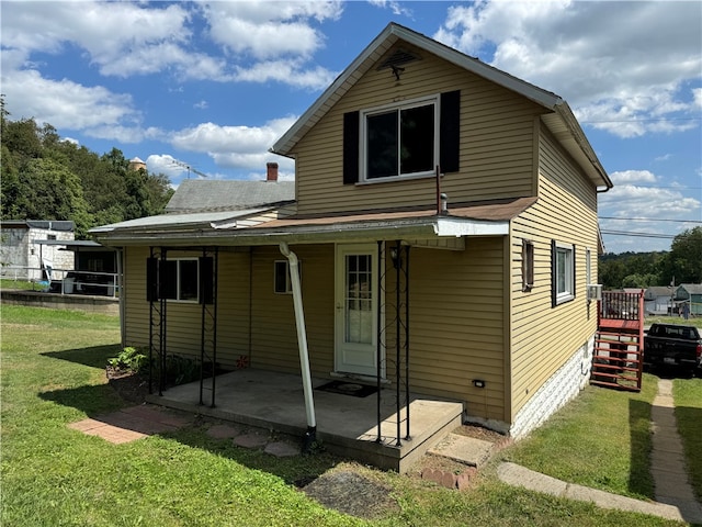 rear view of house with a patio and a yard