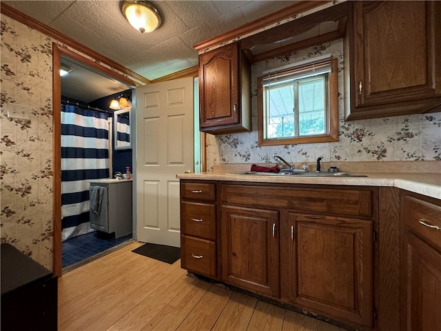 kitchen with sink, light hardwood / wood-style flooring, and dark brown cabinets