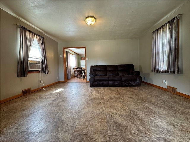 tiled living room with a textured ceiling and cooling unit