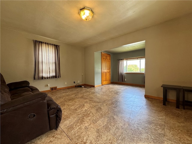 living room featuring a textured ceiling and light tile patterned flooring