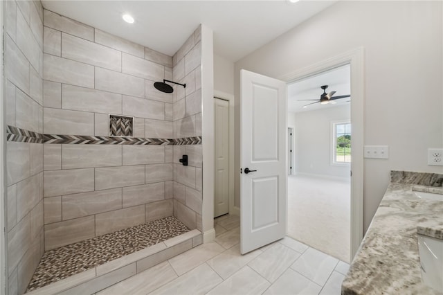 bathroom with ceiling fan, vanity, tile patterned flooring, and a tile shower