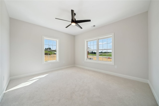 carpeted spare room with plenty of natural light and ceiling fan