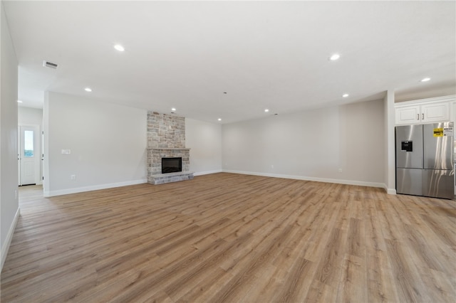 unfurnished living room with a fireplace and light hardwood / wood-style flooring