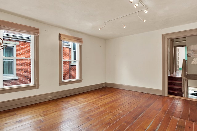 spare room featuring rail lighting and light wood-type flooring