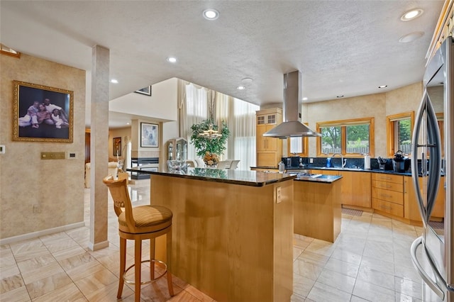 kitchen with kitchen peninsula, island exhaust hood, a center island, and light tile patterned flooring