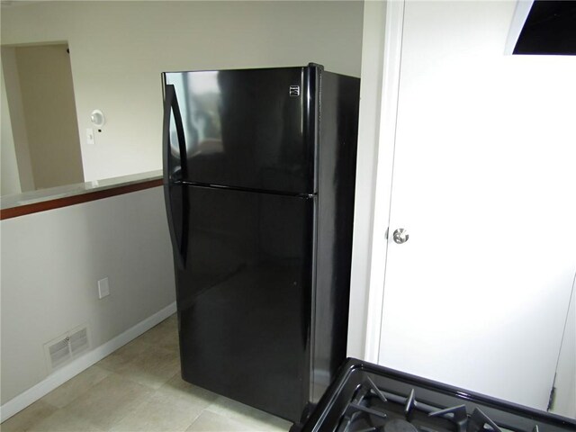 kitchen featuring black refrigerator and light tile patterned floors