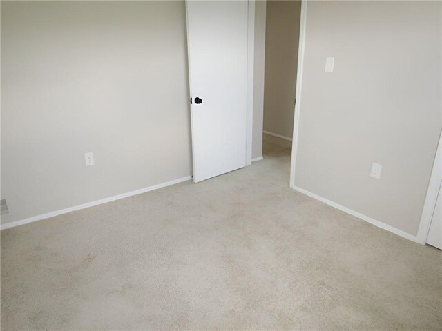 unfurnished room featuring light carpet