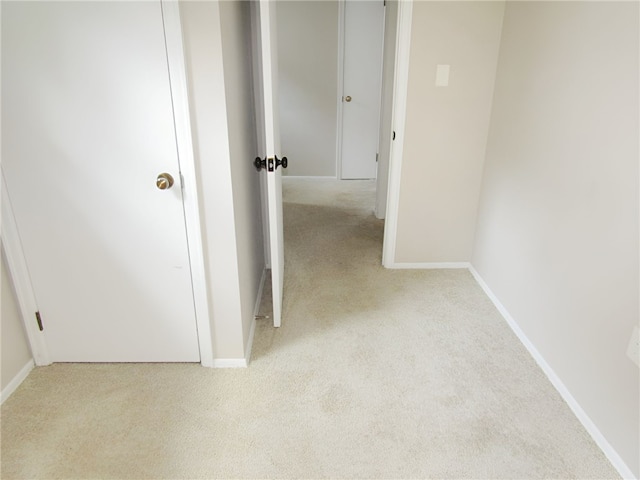 hall with light colored carpet