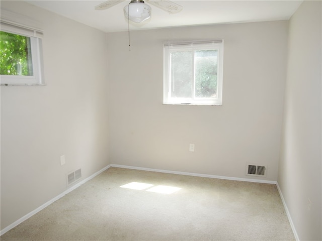 carpeted spare room featuring ceiling fan