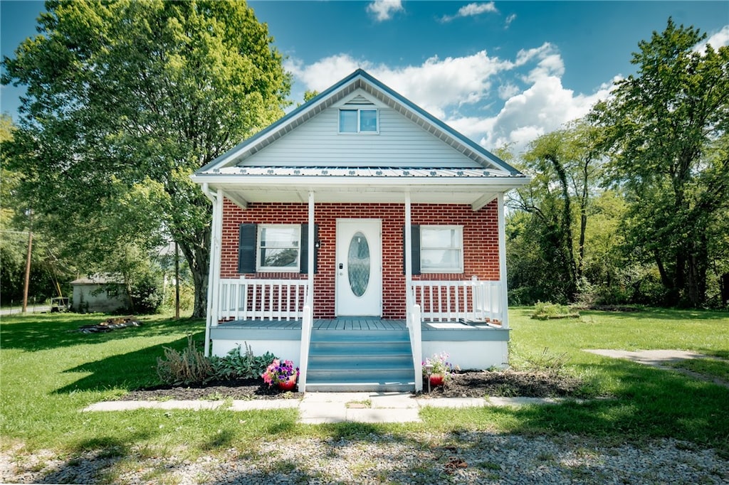 bungalow-style home with covered porch and a front lawn