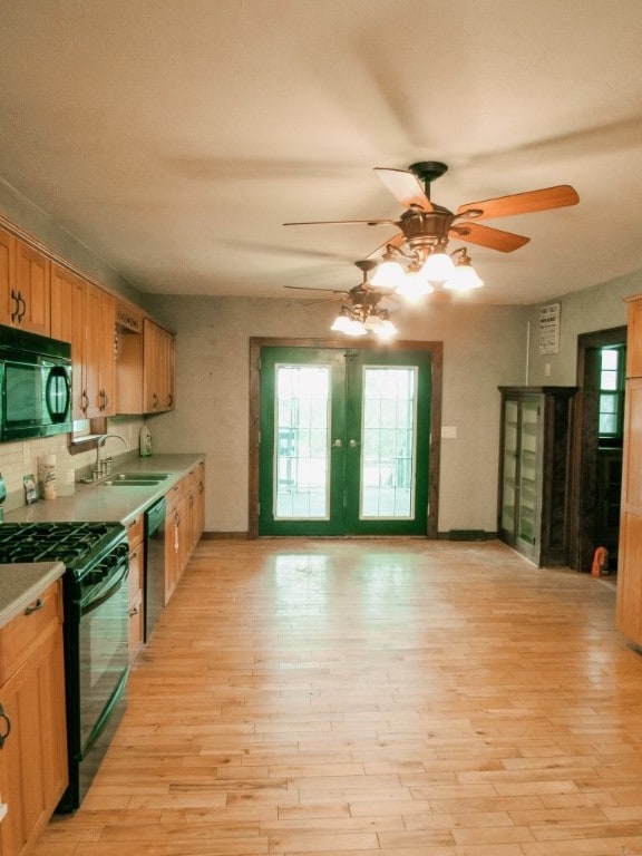 kitchen featuring sink, ceiling fan, light hardwood / wood-style floors, and black appliances