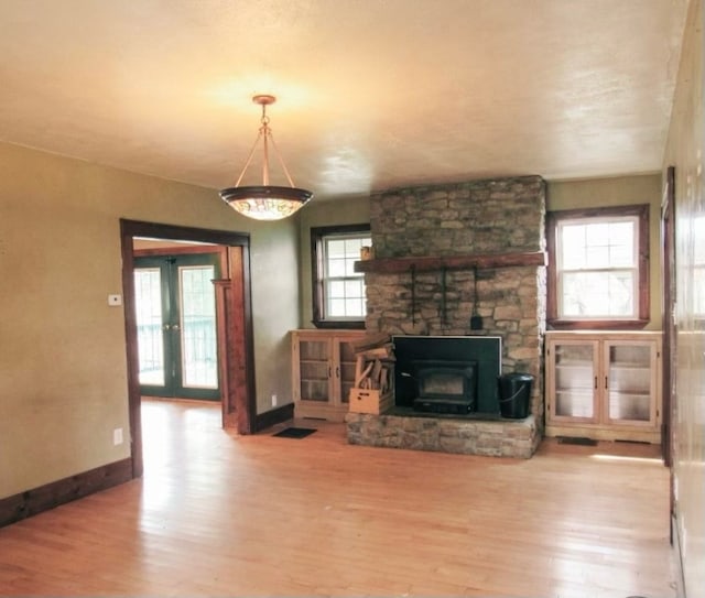 living room with a wealth of natural light, a fireplace, and light hardwood / wood-style flooring